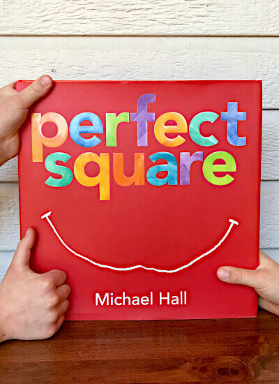 Kids holding picture book Perfect Square and giving it a thumbs up