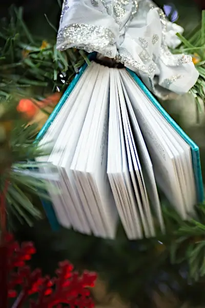 Photo of a Book Ornament hanging on a Christmas Tree for Christmas Books for Kids Post
