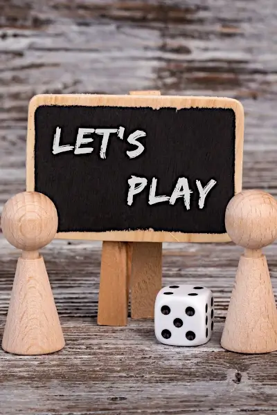 Family Game Night for Fun and Connection - Image shows dice, game pieces, and a sign saying "let's play"